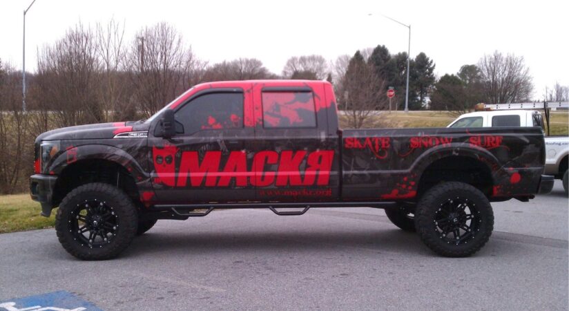 Pickup truck with a custom red and black vinyl truck wrap