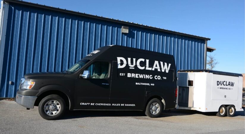 Van and trailer with black and white custom vinyl wraps advertising a Maryland brewery