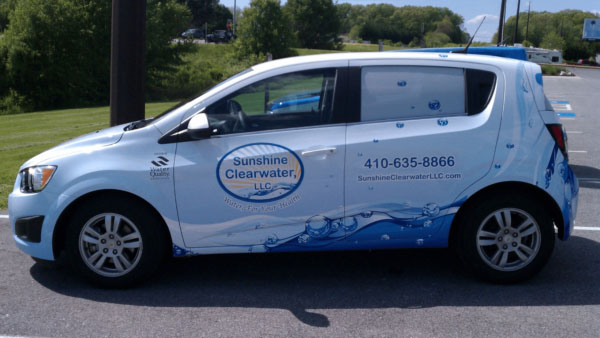 Car with an advertising wrap for a plumbing company