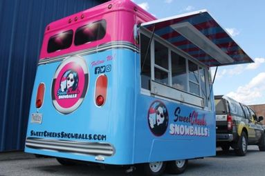 Side view of a food truck with custom wrap signage and graphics