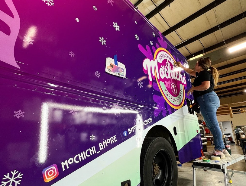 Example of how to install food truck wraps, showing the Mochichi dessert truck partially wrapped in a workshop.
