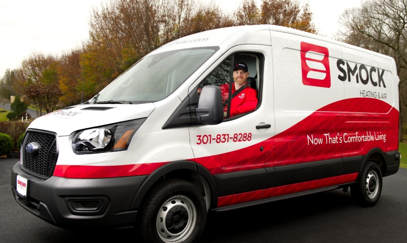 An HVAC technician in the fully wrapped van.