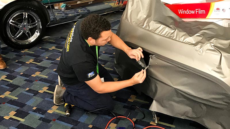 Chris Fong demonstrating vehicle wrap at DC Auto Show