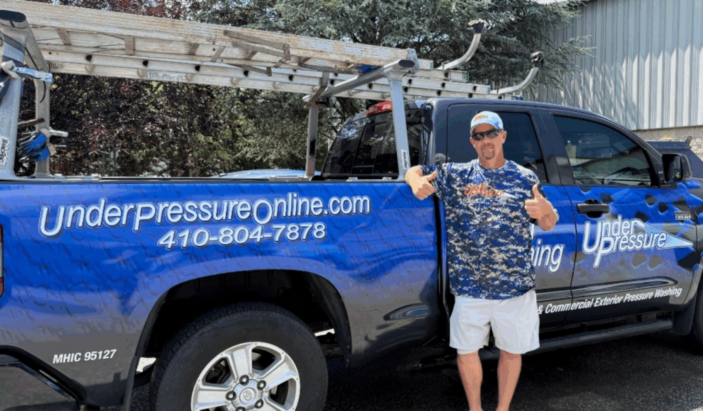 A man in front of a fully wrapped vehicle.